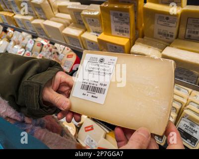 Un acquirente sceglie pacchetti di formaggio Gruyere francese a New York martedì 7 marzo 2023. Un tribunale d'appello statunitense ha stabilito che il nome gruyere può essere utilizzato al di fuori delle regioni Gruyere della Svizzera e della Francia. (© Richard B. Levine) Foto Stock