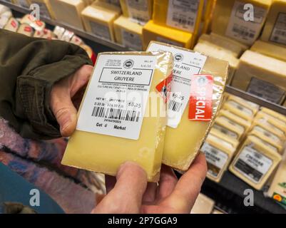 Un acquirente sceglie pacchetti di formaggio svizzero Gruyere a New York martedì 7 marzo 2023. Un tribunale d'appello statunitense ha stabilito che il nome gruyere può essere utilizzato al di fuori delle regioni Gruyere della Svizzera e della Francia. (© Richard B. Levine) Foto Stock