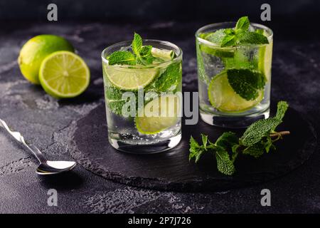 Cocktail analcolico estivo rinfrescante mojito con ghiaccio, menta fresca e lime, focus selettivo Foto Stock