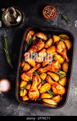 Cosce di pollo arrosto con patate e rosmarino. Vista dall'alto. Foto Stock