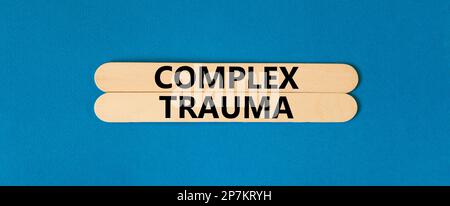 Simbolo di trauma complesso. Concetto parole trauma complesso su bastoni di legno. Bellissimo sfondo blu tavolo. Psicologia aziendale concetto di trauma complesso Foto Stock