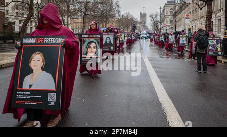 Marciando a Whitehall, donne protestanti anglo-iraniane vestite come personaggi della storia dell'Angiena in occasione dell'International Women's Day 2023. Foto Stock