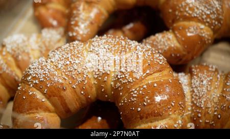 File di panini caldi appena sfornati in esposizione presso il panificio locale Foto Stock