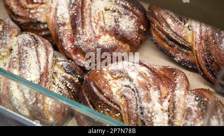 File di panini caldi appena sfornati in esposizione presso il panificio locale Foto Stock