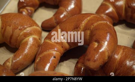 File di panini caldi appena sfornati in esposizione presso il panificio locale Foto Stock