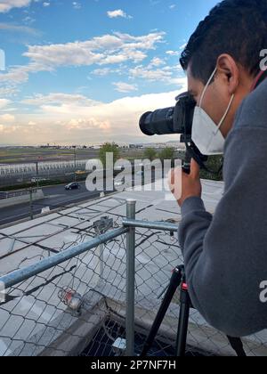 Fotografo professionista con maschera che scatta foto del paesaggio Foto Stock