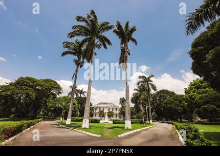 Lo storico sito patrimonio della Devon House a Kingston, Giamaica, è circondato da una splendida vegetazione. Foto Stock