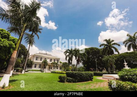 Lo storico sito patrimonio della Devon House a Kingston, Giamaica, è circondato da una splendida vegetazione. Foto Stock