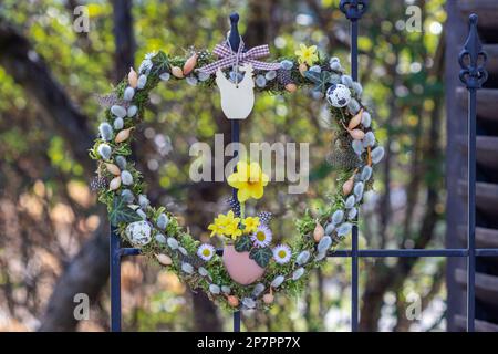 corona a forma di cuore con moos, cetriolini di salice, set di cipolle e fiori di narciso Foto Stock