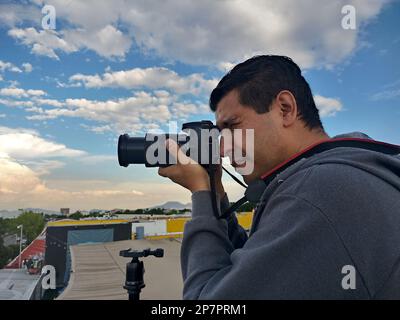 Fotografo professionista con maschera che scatta foto del paesaggio Foto Stock