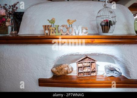 Primo piano di decorazioni disposte su mensole di legno in un hotel di lusso Foto Stock