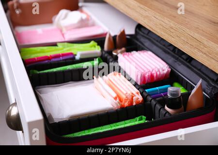 Cassettiera aperta con tamponi mestruali, tamponi e prodotti per la cura della pelle, primo piano Foto Stock