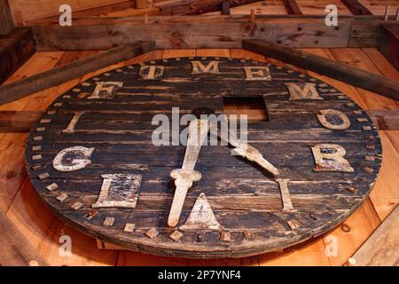 Un orologio fatto a mano alle intemperie pende su una palla fienile al Tuck Museum of Hampton History. Hampton, New Hampshire. Foto Stock