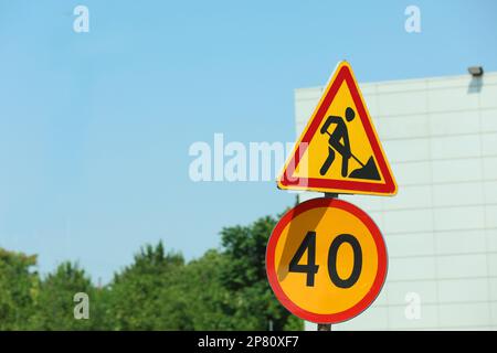 Costruzione di strade e segnaletica per limiti di velocità all'aperto nelle giornate di sole. Interventi di riparazione Foto Stock