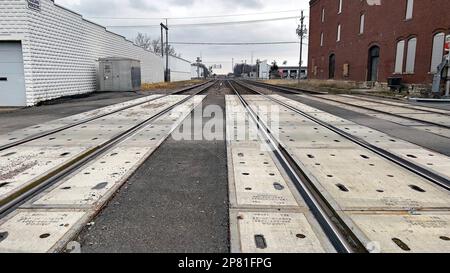 EMPORIA, KANSAS - 8 MARZO 2023 BNSF triplo binario ferroviario alla strada commerciale che attraversa guardando verso ovest verso il cantiere di marshalling ferroviario Foto Stock