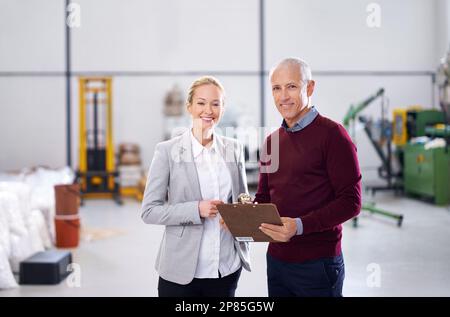 Si assicurano che questo posto funzioni efficientemente. Ritratto di due responsabili di fabbrica che eseguono un'ispezione. Foto Stock