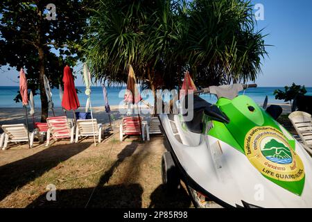 Vista mattutina di Surin Beach, Phuket, Thailandia, con sedie a sdraio, ombrelloni e moto d'acqua ancora vuoti Foto Stock