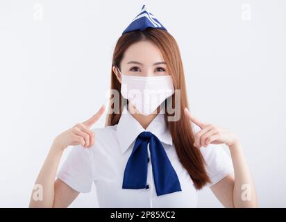 Giovane donna hostess aria in uniforme con maschera bianca Foto Stock