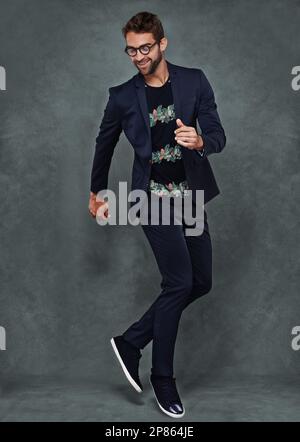 Stile in movimento. Studio di un giovane vestito elegantemente. Foto Stock