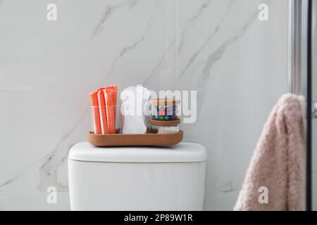 Organizer con diversi prodotti per l'igiene femminile sul water in bagno Foto Stock