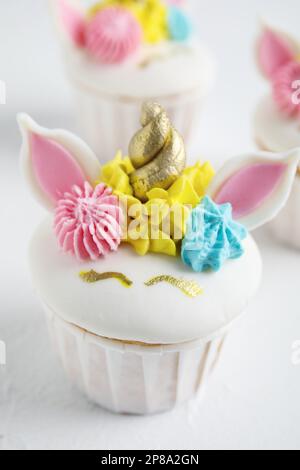 Cupcake dolce carino unicorno su tavolo bianco, primo piano Foto Stock