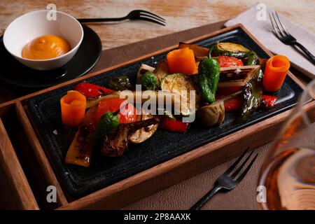 Piatto di verdure arrosto al forno come carote, peperone verde, pomodori e porri. Foto Stock