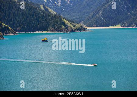 Il bellissimo paesaggio del Lago Tianchi nei Monti Tianshan, Xinjiang, con montagne innevate in lontananza, e il vasto e verde Tianhu Lak Foto Stock