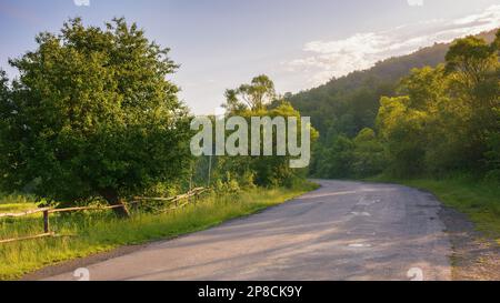 la strada si snoda attraverso la lussureggiante campagna. fai un giro attraverso le pittoresche fattorie dei dintorni rurali Foto Stock