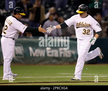 Oakland Athletics' Jack Cust, right, gets a handshake from third base coach  Tony DeFrancesco after Cust hit a two-run home run off Texas Rangers' Eric  Hurley in the first inning of a