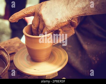 Primo piano di un vasaio che forma l'argilla sulla ruota di un vasaio Foto Stock