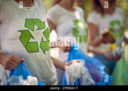 Gruppo di giovani che si offrono volontariamente, raccogliendo rifiuti. Pulizia della natura dai rifiuti. Ambientalismo, concetto di stile di vita. Foto Stock