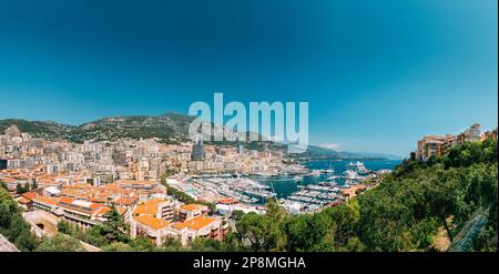 Il Principato di Monaco e Monte Carlo cityscape. Immobiliare di Architettura in montagna collina sullo sfondo. Molti edifici ad alta nell area del centro cittadino. Yacht ormeggiati in città Foto Stock