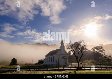 Storica piccola chiesa cittadina nella contea di West Marin sotto la nebbia e il sole mattutino Foto Stock