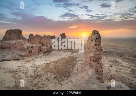 Rovine dell'antica fortezza di Khorezm Ayaz Kala nel deserto di Kyzylkum all'alba, Uzbekistan Foto Stock