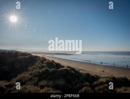 Sole d'inverno sulla spiaggia di Saunton Sands, North Devon, Inghilterra. Immagine ripresa dalle dune che portano alla spiaggia di sabbia con la bassa marea nel mese di dicembre Foto Stock