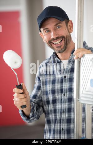 costruttore o riparatore con barba folta sorridente alla telecamera Foto Stock