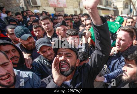 Jenin, Palestina, 09/03/2023, i parenti salutano il corpo di uno dei tre palestinesi uccisi dall'esercito israeliano durante i funerali nella città di Jaba, nei pressi di Jenin, nella Cisgiordania occupata. Le forze israeliane speciali dell'unità coperta hanno assassinato tre palestinesi, all'ingresso della città di Jaba, i testimoni hanno aggiunto che le grandi forze dell'esercito israeliano hanno rotto nella città e dispiegato cecchini sui tetti delle case, Constatando che la forza speciale si è infiltrata con un veicolo che porta una targa di immatricolazione palestinese. Foto Stock