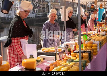 Venditori di formaggio femminile con abbigliamento tradizionale in una bancarella del mercato del formaggio Alkmaar nei Paesi Bassi. Foto Stock