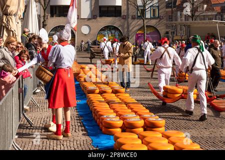 Portaroformaggi e ragazze con scarpe di legno al mercato olandese del formaggio ad Alkmaar. Foto Stock