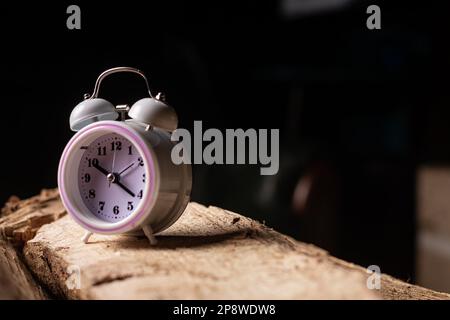 Sveglia su sfondo scuro. Concetto di gestione del tempo. Ritmi circadiani. Foto Stock