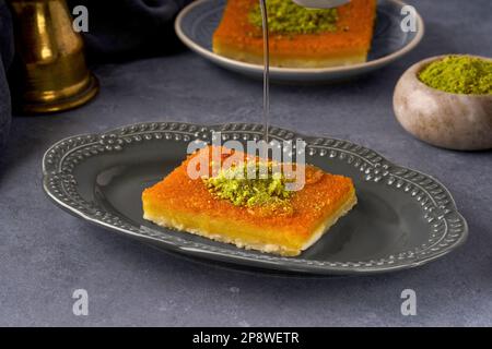 Dolci mediorientali kunefe, kunafa, kadayif con pistacchio e sciroppo. Turco, tradizionale dessert arabo. Foto Stock