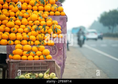 Arance kinnu agrumi accatastato in una bancarella su strada mostrando come gli agricoltori tradizionalmente vendere questa frutta locale in India per mangiare e succo come un Foto Stock