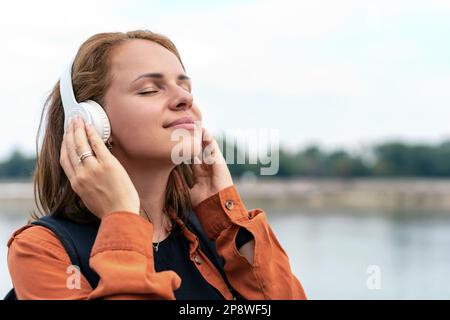 Donna in cuffia ama la musica. Foto Stock