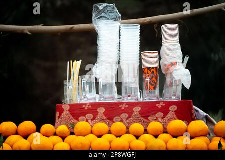 gli agrumi di arance kinnu si sono ammassati in un chiosco sul lato della strada con bicchieri per spremute fresche e serviti sul lato della strada nel caldo summar Foto Stock