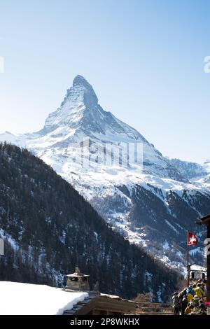Vista sul Cervino dal sentiero escursionistico a Sunnegga da Zermatt, Svizzera, con una bandiera svizzera in primo piano. Foto Stock