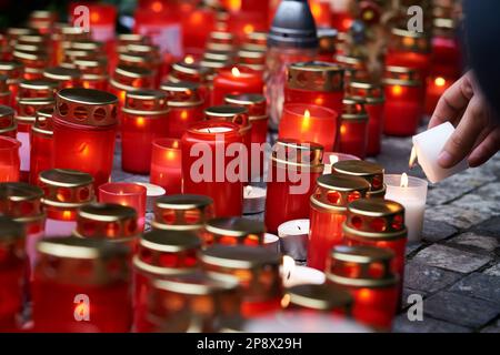 La mano umana accende una candela in occasione dell'anniversario della Rivoluzione di velluto il 17th novembre a Praga, in Cechia Foto Stock