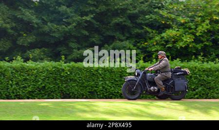 SILSOE, BEDFORDSHIRE, INGHILTERRA - 14 AGOSTO 2021: Guerra mondiale 2 BMW R71 Motorcycle e Sidecar con la pistola di macchina che è guidato da uomo in uniforme tedesca. Foto Stock