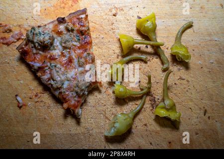 Pezzetti di pizza di tonno e pepperoni pezzetti su una tavola di legno Foto Stock