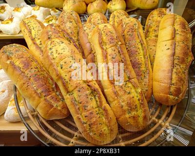 Disposizione di pane all'aglio in un negozio di panetteria. Foto Stock