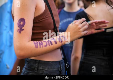 Buenos Aires, Argentina; 8 marzo 2023: Sciopero femminista internazionale. Donna irriconoscibile che ha dipinto sul braccio, in viola, il simbolo delle donne Foto Stock